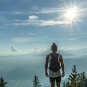 Female Hiker ales-krivec-HTs3iPHpPZs-unsplash CRP3 A solitary hiker with a backpack standing on a mountain peak looking out over misty valleys and layered hills under a bright sun, representing the hero's journey to the Authentic Self for highly sensitive introverts.