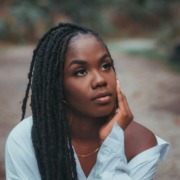 Close-up portrait of a contemplative young Black woman looking upward in quiet reflection, symbolizing deep emotional healing, vulnerability, and inner peace.