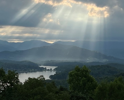 Dramatic sunbeams breaking through storm clouds over Lake Chatuge and the Blue Ridge Mountains.