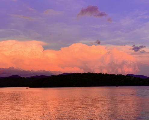 Panoramic view of peach sunset clouds reflecting on Lake Chatuge and the Blue Ridge Mountains near Young Harris, GA.