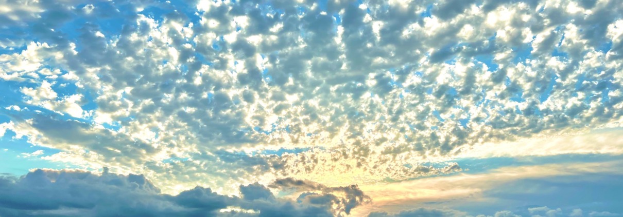Expansive blue sky filled with textured white clouds, symbolizing the neural expansion achieved at HSP Breathwork Retreats.