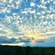 Expansive blue sky filled with textured white clouds, symbolizing the neural expansion achieved at HSP Breathwork Retreats.