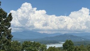 Scenic overlook of Lake Chatuge and the Blue Ridge Mountains under a bright blue sky with large white cumulus clouds, Young Harris, GA.