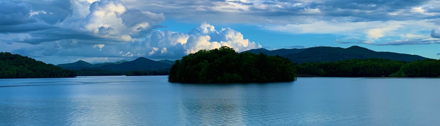 Towering white clouds over Lake Chatuge and Blue Ridge Mountains, symbolizing Ellen's HSP Retreat transformation.