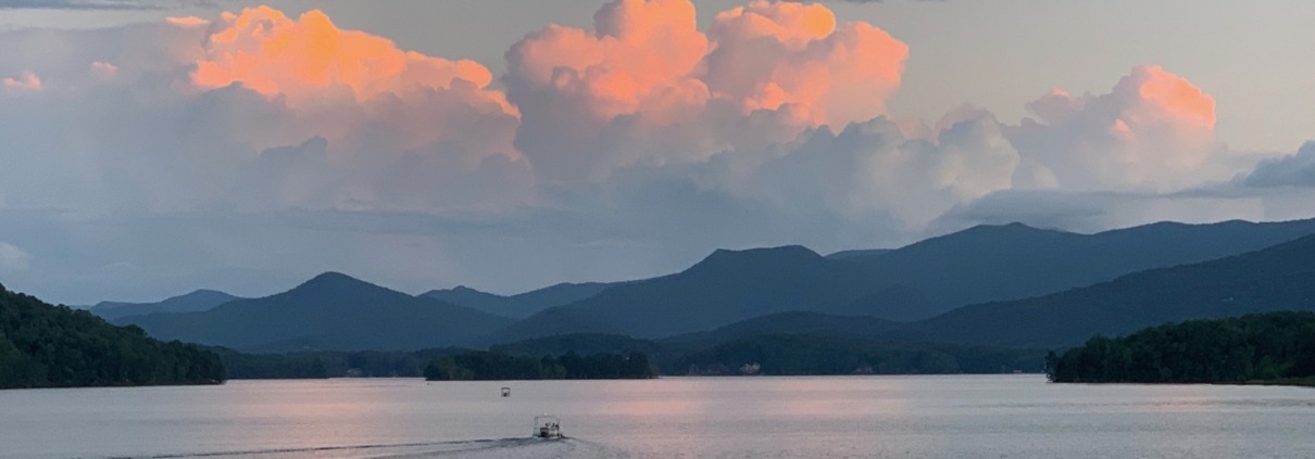 Sunset over Lake Chatuge in NC and GA, featuring peach clouds over the Blue Ridge Mountains, venue of our HSP Retreats.