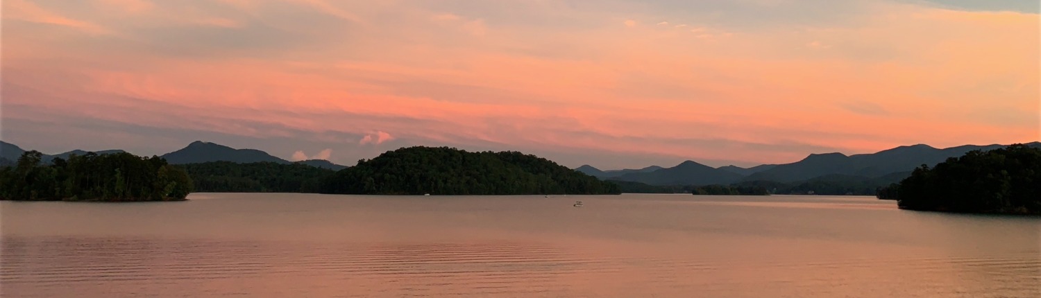Lake Chatuge in the Blue Ridge Mountains during a peach sunset, showcasing the healing power of nature for HSP retreats led by Benita Esposito