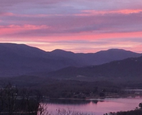 Panoramic view of a pink sunrise over the Blue Ridge Mountains and Lake Chatuge in Young Harris, Georgia.