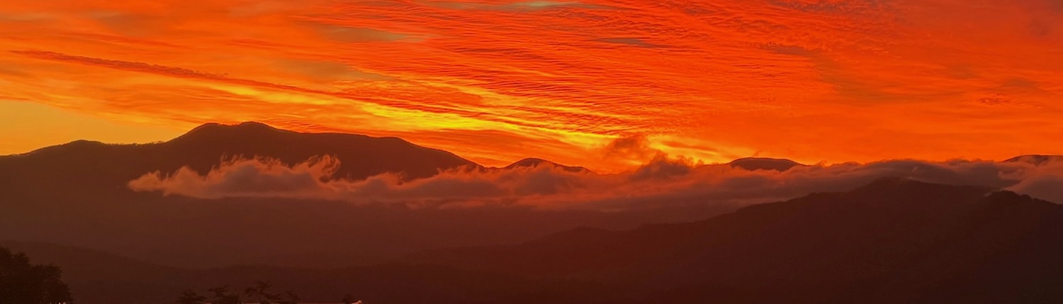 Panoramic orange sunset over Lake Chatuge and the Blue Ridge Mountains near Young Harris, Georgia.