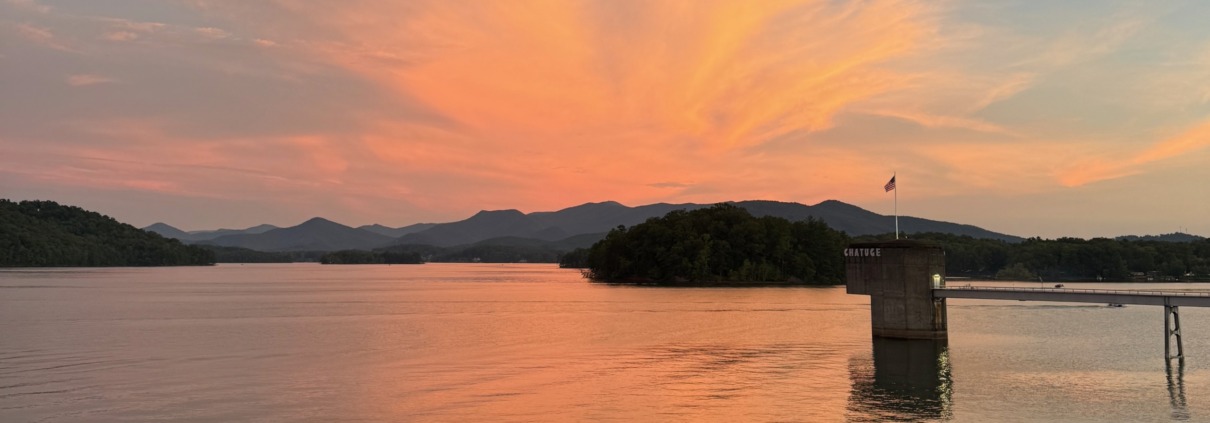 Panoramic orange sunset over Lake Chatuge and the Blue Ridge Mountains near Young Harris, Georgia.