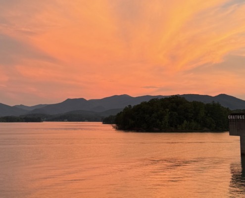Panoramic orange sunset over Lake Chatuge and the Blue Ridge Mountains near Young Harris, Georgia.