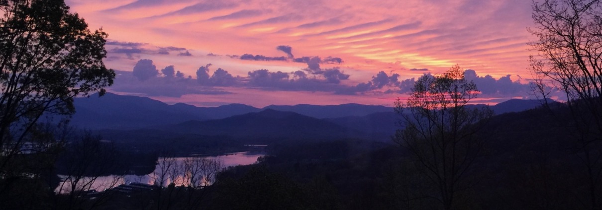 Panoramic view of a soft pink and purple dawn sky over Lake Chatuge and the Blue Ridge Mountains in Young Harris, Georgia.