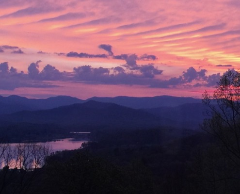 Panoramic view of a soft pink and purple dawn sky over Lake Chatuge and the Blue Ridge Mountains in Young Harris, Georgia.