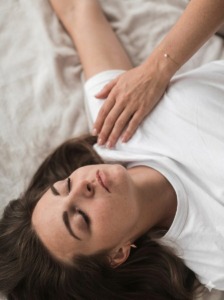 Somatic breathwork session at an HSP Retreat with a practitioner's supportive hand grounding a woman during emotional trauma healing.
